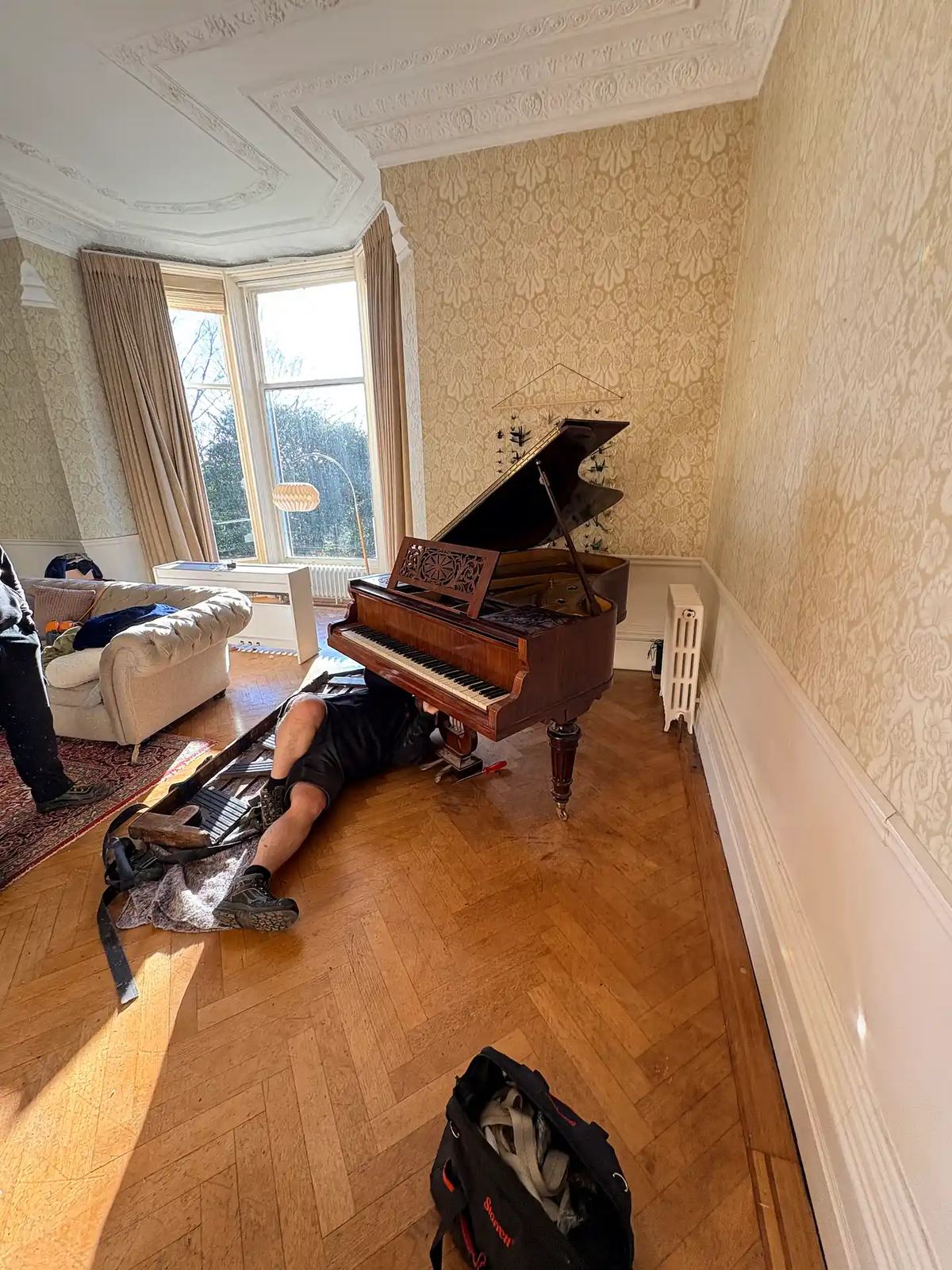 Grand piano being moved on a padded skid