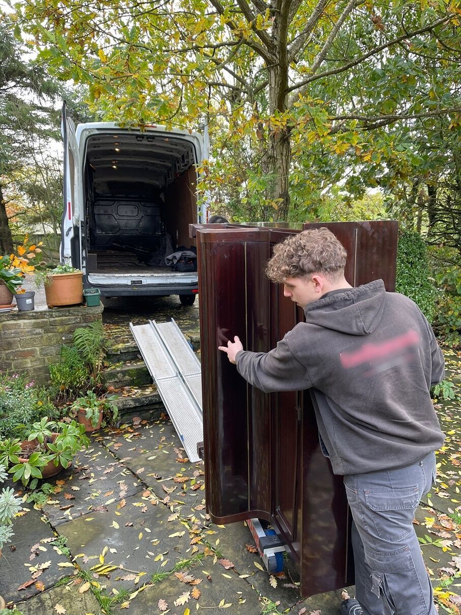Loading a piano into the removal van for disposal