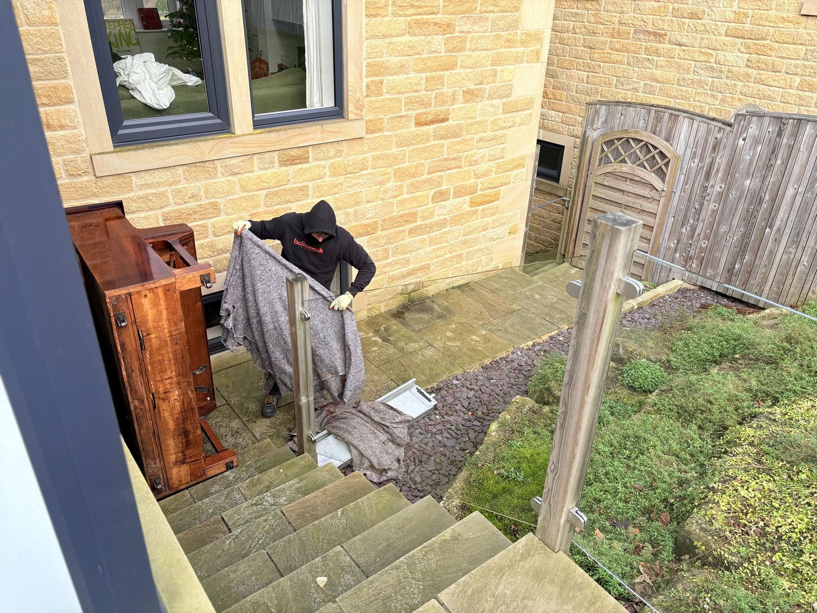 Upright piano ready for removal in a Manchester home