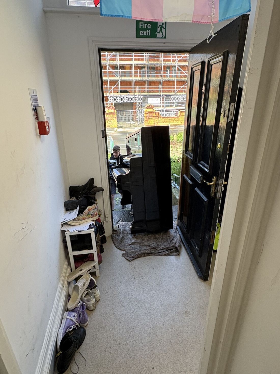 Upright piano being moved through a doorway